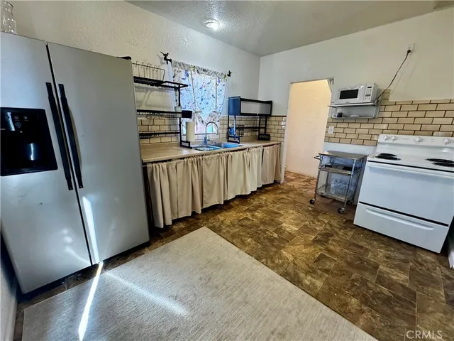 a kitchen with refrigerator and white stove