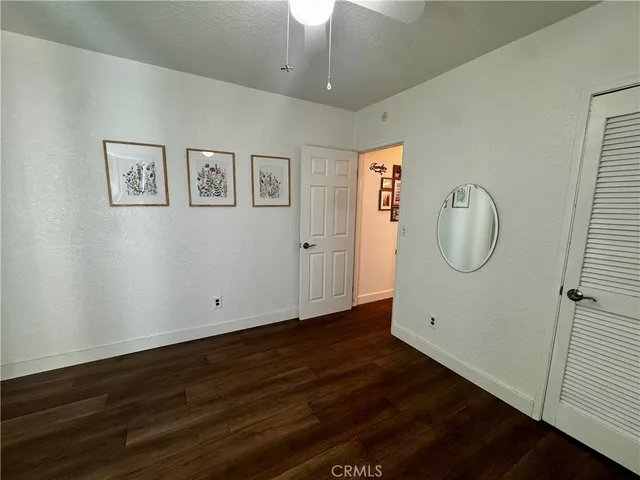 a view of a room with wooden floor fan and windows