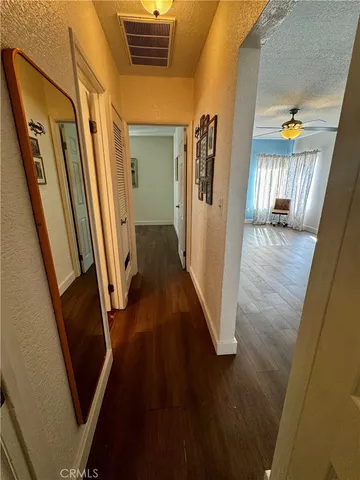 a view of a hallway with wooden floor and stairs