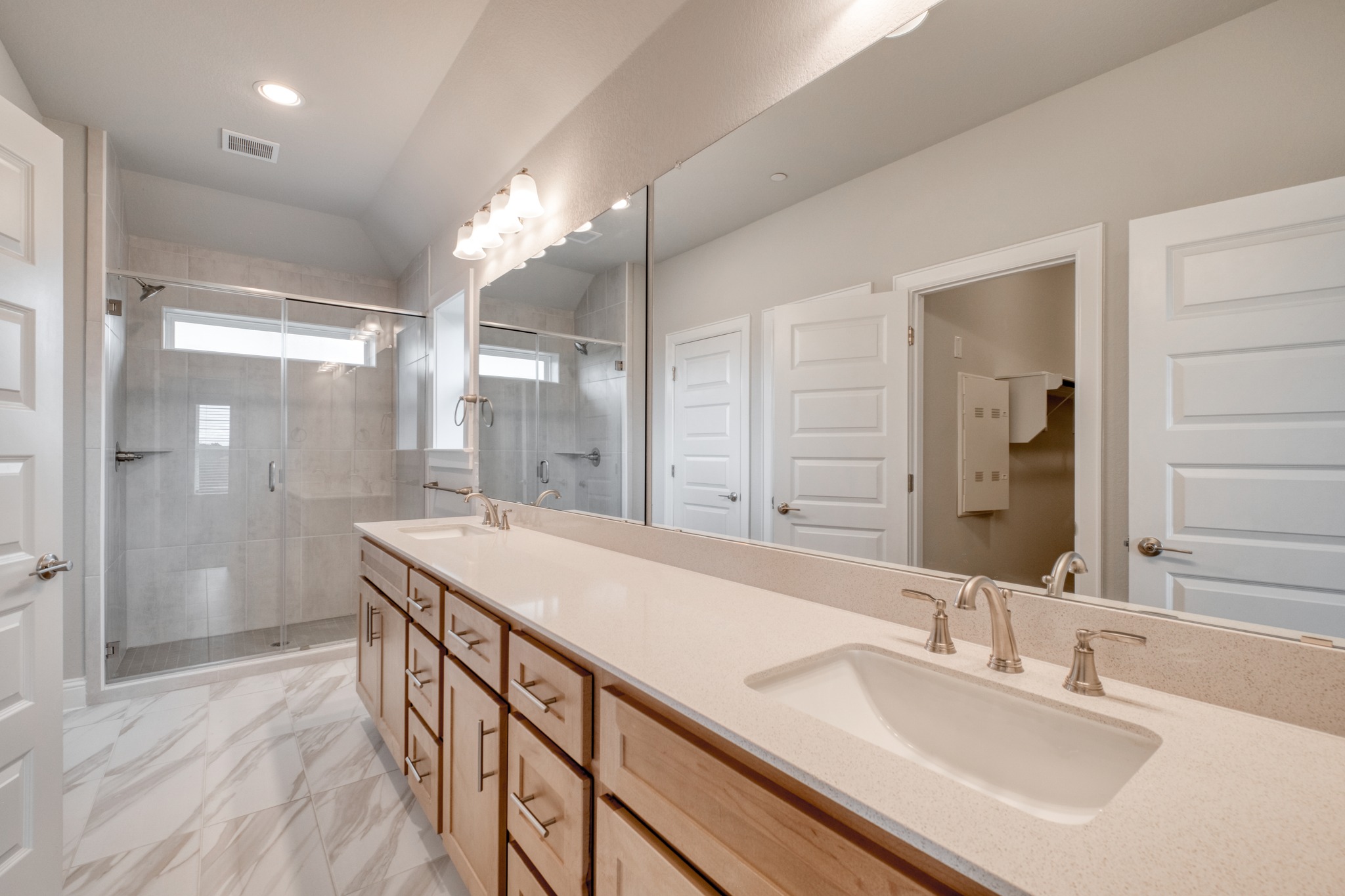 2605 Sam Bass Road, Unit 44 Round Rock, TX 78681 - Photo 18 of 26 A spacious primary bathroom with a double vanity and a glass-enclosed shower stall.