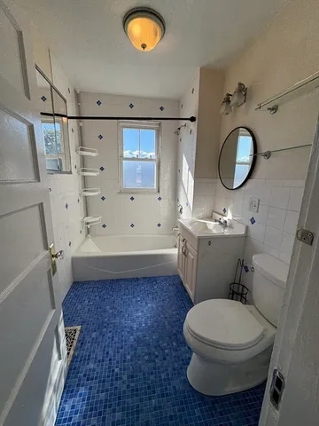 a bathroom with a toilet a sink and a mirror