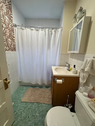 a bathroom with a sink a toilet and shower curtain