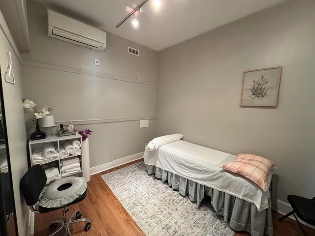 a bedroom with a bed a flat screen tv and dresser