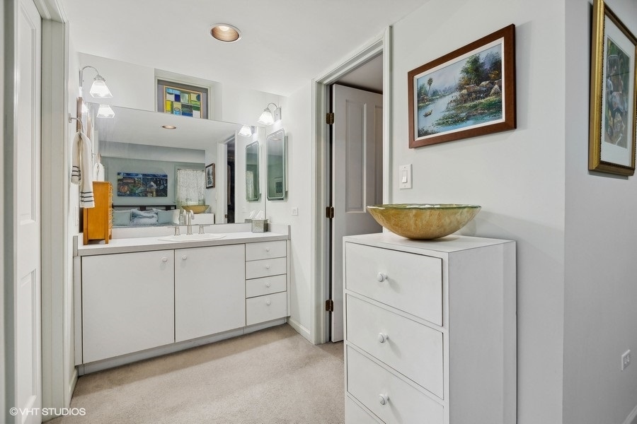 Undisclosed Address Chicago, IL 60657 - Photo 17 of 40 a bathroom with a sink a mirror and a vanity