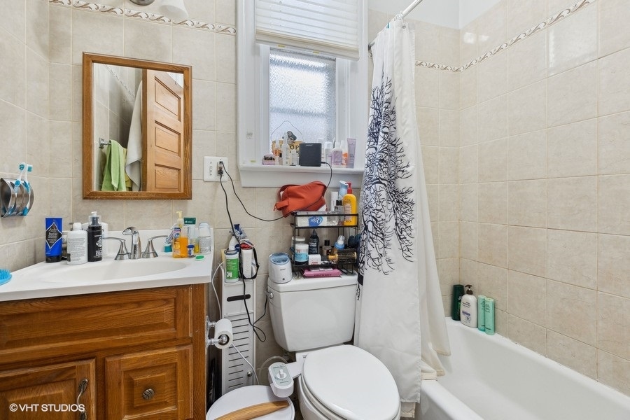 Undisclosed Address Chicago, IL 60657 - Photo 21 of 40 a bathroom with a toilet a sink and a mirror