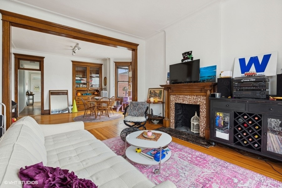 Undisclosed Address Chicago, IL 60657 - Photo 24 of 40 a living room with furniture a flat screen tv and a fireplace