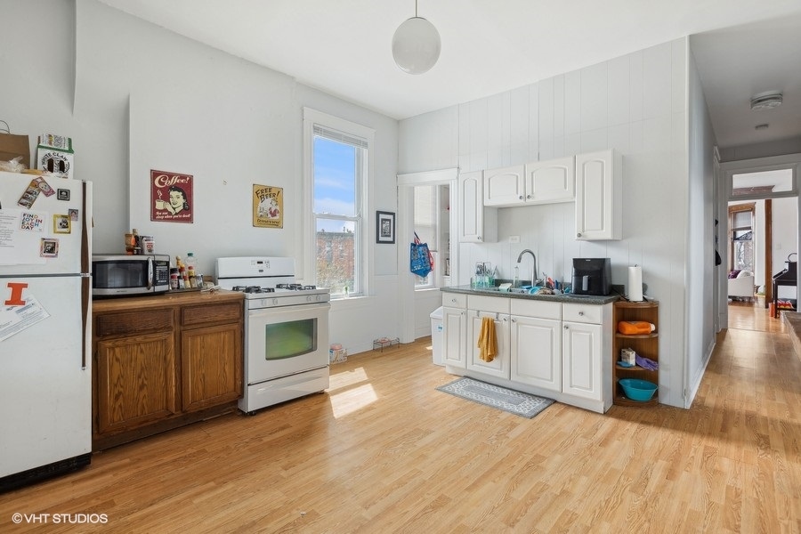 Undisclosed Address Chicago, IL 60657 - Photo 26 of 40 a kitchen with stainless steel appliances granite countertop a stove and white cabinets