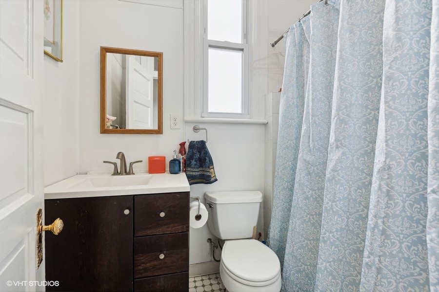 Undisclosed Address Chicago, IL 60657 - Photo 29 of 40 a bathroom with a toilet a sink a vanity and mirror