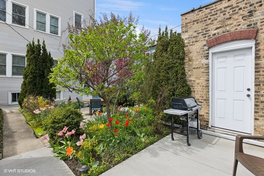 Undisclosed Address Chicago, IL 60657 - Photo 34 of 40 a garden with a bench and some trees