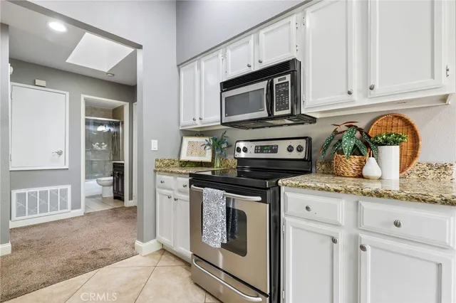 a kitchen with stainless steel appliances granite countertop a stove a microwave and cabinets