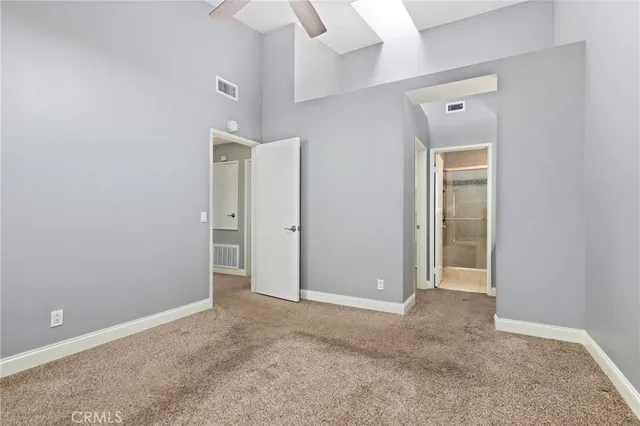 an empty room with closet and a chandelier fan