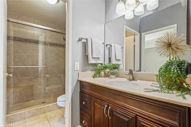 a bathroom with a granite countertop sink a toilet and shower
