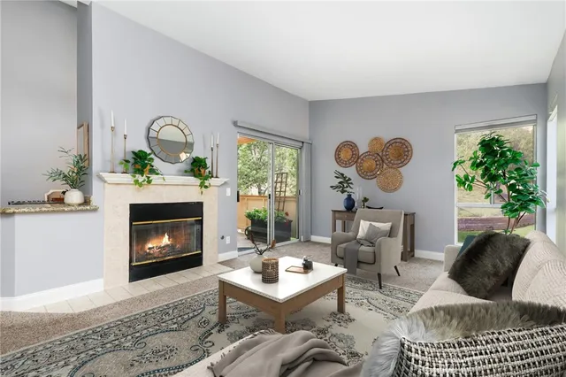 a living room with furniture a fireplace and a potted plant
