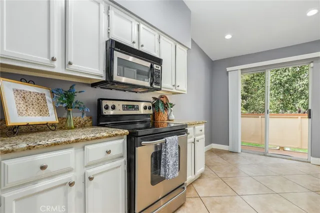 a kitchen with granite countertop a stove top oven microwave and cabinets