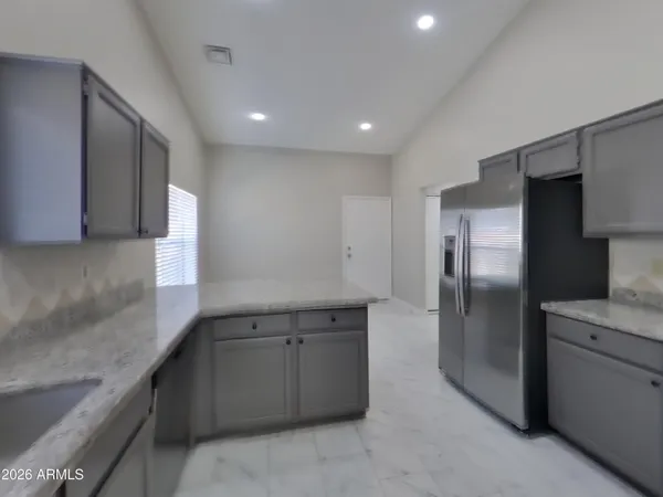 a kitchen with stainless steel appliances granite countertop a refrigerator and a sink