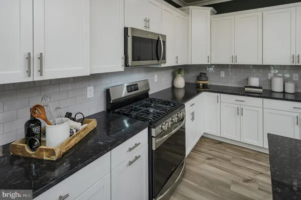 a kitchen with granite countertop a stove sink and cabinets