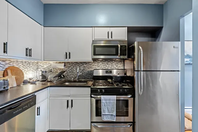 a kitchen with appliances a sink and cabinets