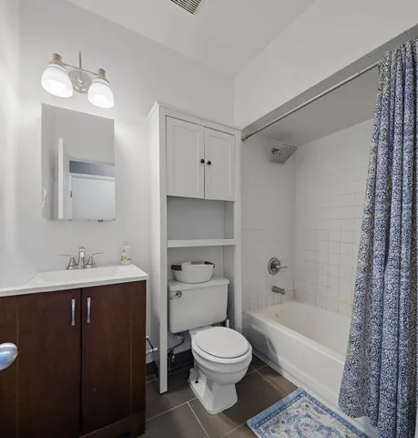 a bathroom with a toilet a sink a mirror a bathtub and vanity