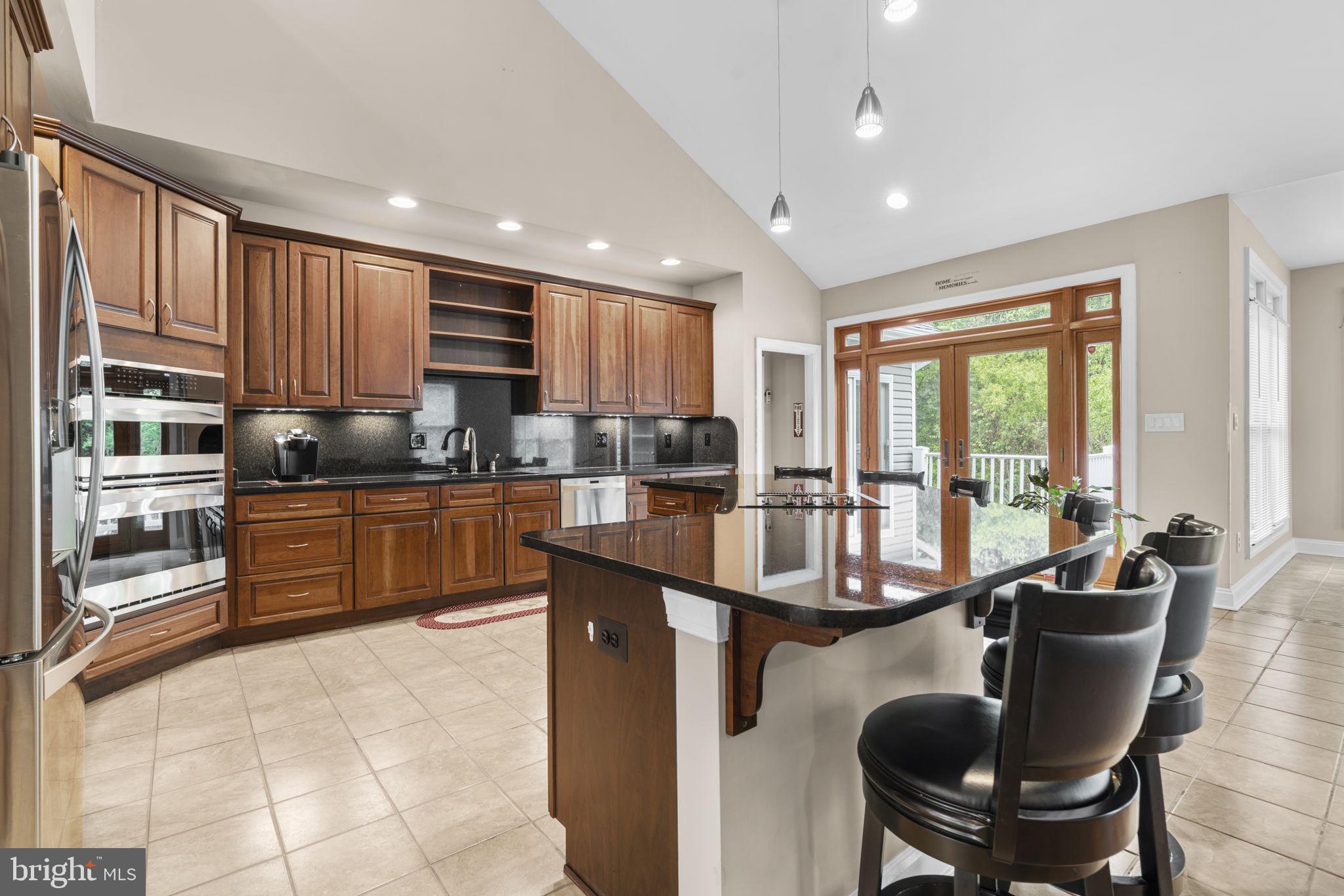 8024 Solley Road Glen Burnie, MD 21060 - Photo 26 of 83 a kitchen with stainless steel appliances granite countertop a stove top oven a sink dishwasher a dining table and chairs with wooden floor