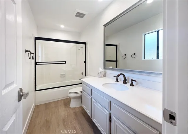 a bathroom with a double vanity sink toilet mirror and shower