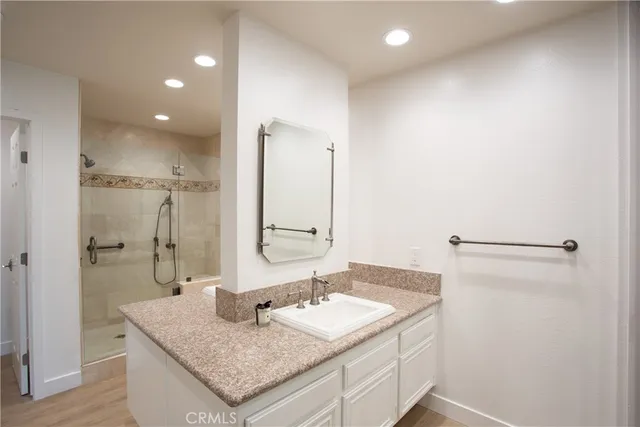 a bathroom with a granite countertop sink and a mirror