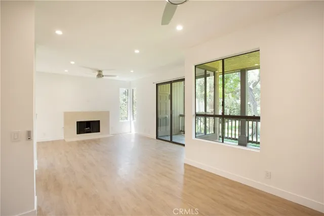 an empty room with wooden floor and a fireplace