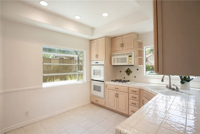 a large white kitchen with cabinets and a window