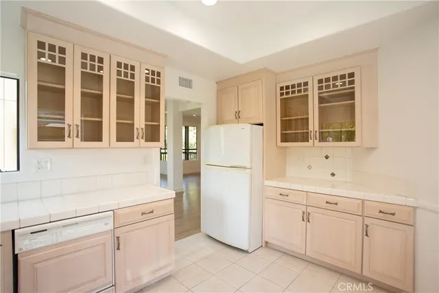 a kitchen with white cabinets and white appliances