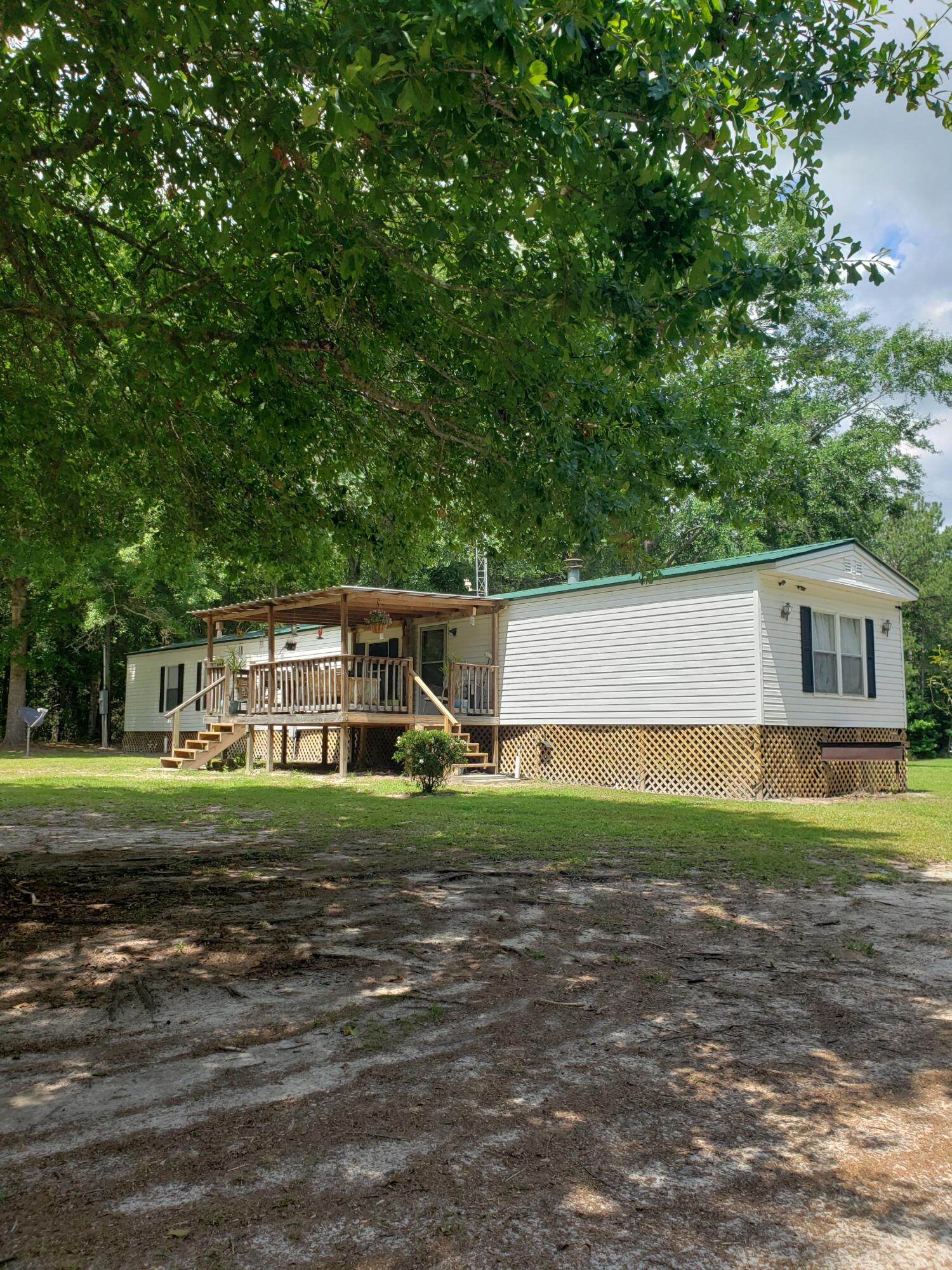 290 Beck Bridge Road Westville, FL 32464 - Photo 1 of 13 a front view of a house with a yard and trees