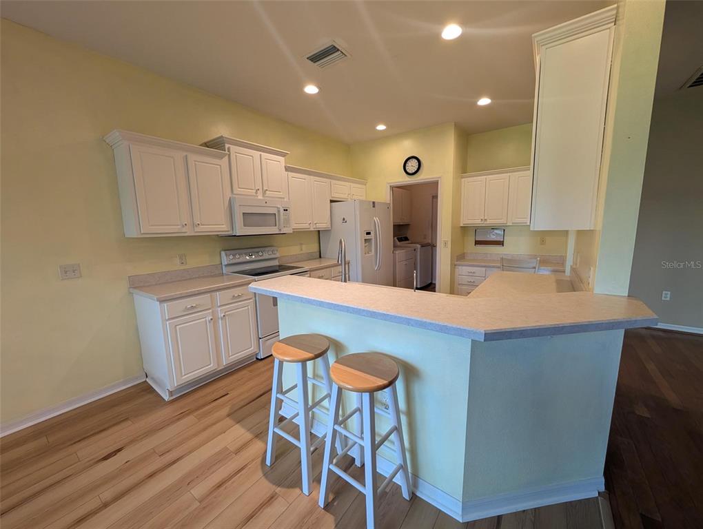 4124 Muirfield Loop Lake Wales, FL 33859 - Photo 12 of 29 a kitchen with stainless steel appliances kitchen island granite countertop a table chairs sink and cabinets