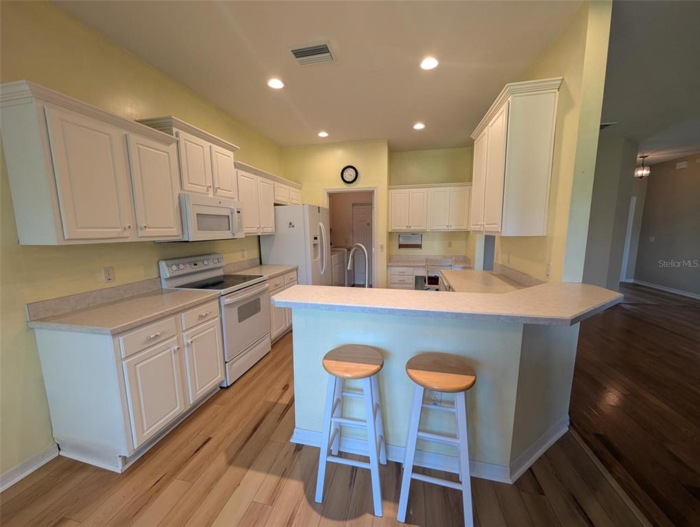 4124 Muirfield Loop Lake Wales, FL 33859 - Photo 13 of 29 a kitchen with a table chairs sink and cabinets