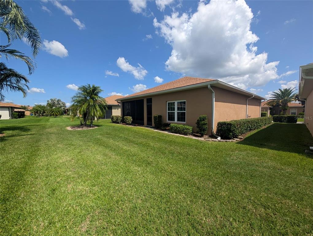 4124 Muirfield Loop Lake Wales, FL 33859 - Photo 27 of 29 a view of a house with a big yard and potted plants