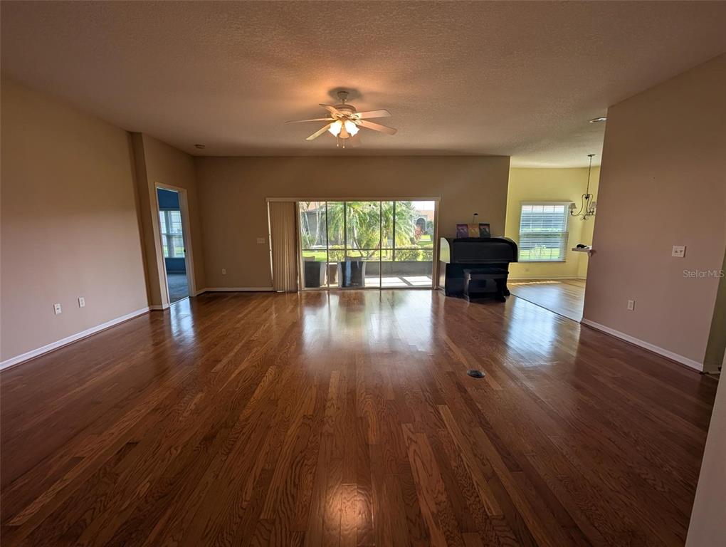 4124 Muirfield Loop Lake Wales, FL 33859 - Photo 3 of 29 a view of empty room with wooden floor and fan