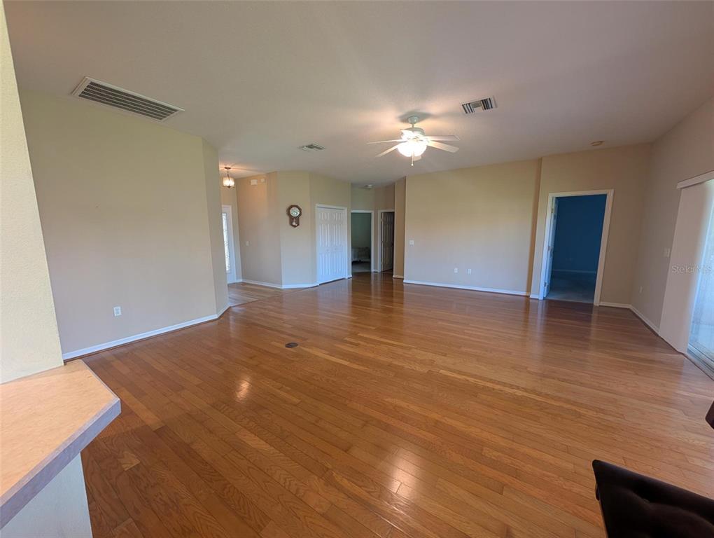 4124 Muirfield Loop Lake Wales, FL 33859 - Photo 9 of 29 a view of an empty room with wooden floor and a ceiling fan