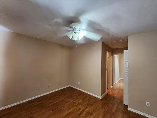 a view of a room with wooden floor and a ceiling fan