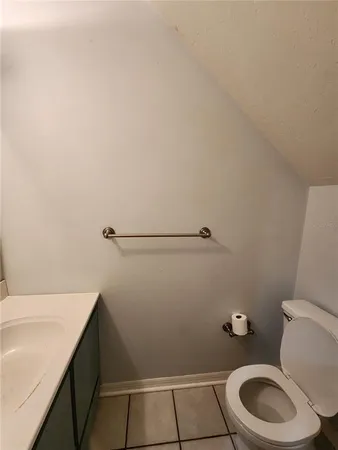 a bathroom with a granite countertop toilet and a sink