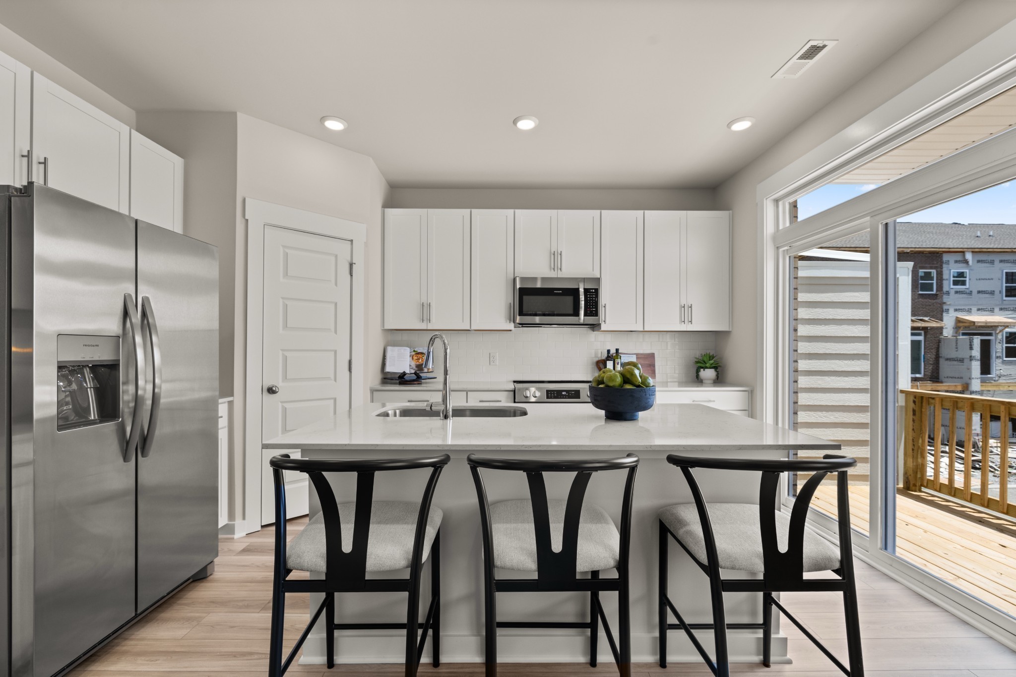 a kitchen with stainless steel appliances a table chairs refrigerator and cabinets