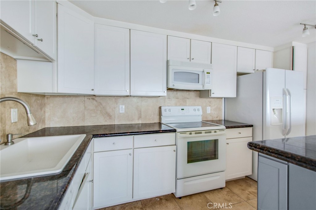 330 Cliff Drive, Unit 308 Laguna Beach, CA 92651 - Photo 11 of 16 a kitchen with white cabinets and white appliances