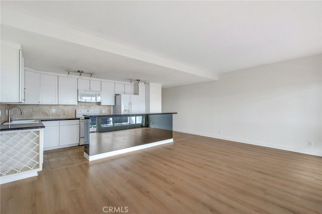 330 Cliff Drive, Unit 308 Laguna Beach, CA 92651 - Photo 12 of 16 a kitchen with granite countertop a stove and a wooden floors