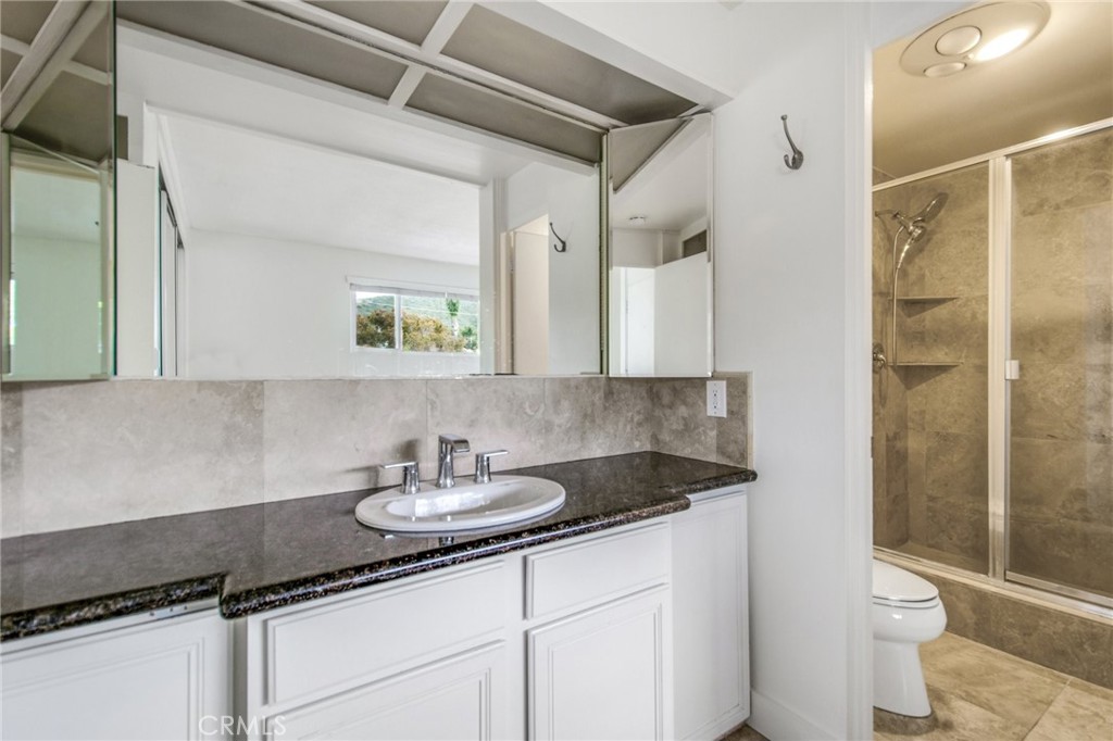 330 Cliff Drive, Unit 308 Laguna Beach, CA 92651 - Photo 15 of 16 a bathroom with a granite countertop sink a toilet and shower