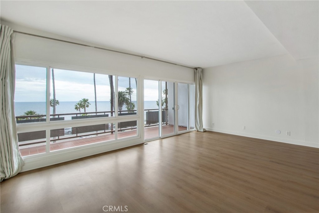 330 Cliff Drive, Unit 308 Laguna Beach, CA 92651 - Photo 6 of 16 an empty room with wooden floor and windows