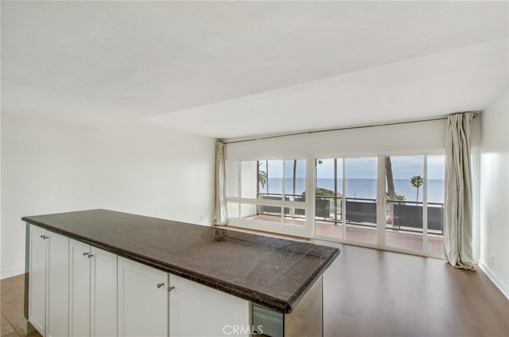 330 Cliff Drive, Unit 308 Laguna Beach, CA 92651 - Photo 7 of 16 an empty room with wooden floor and windows