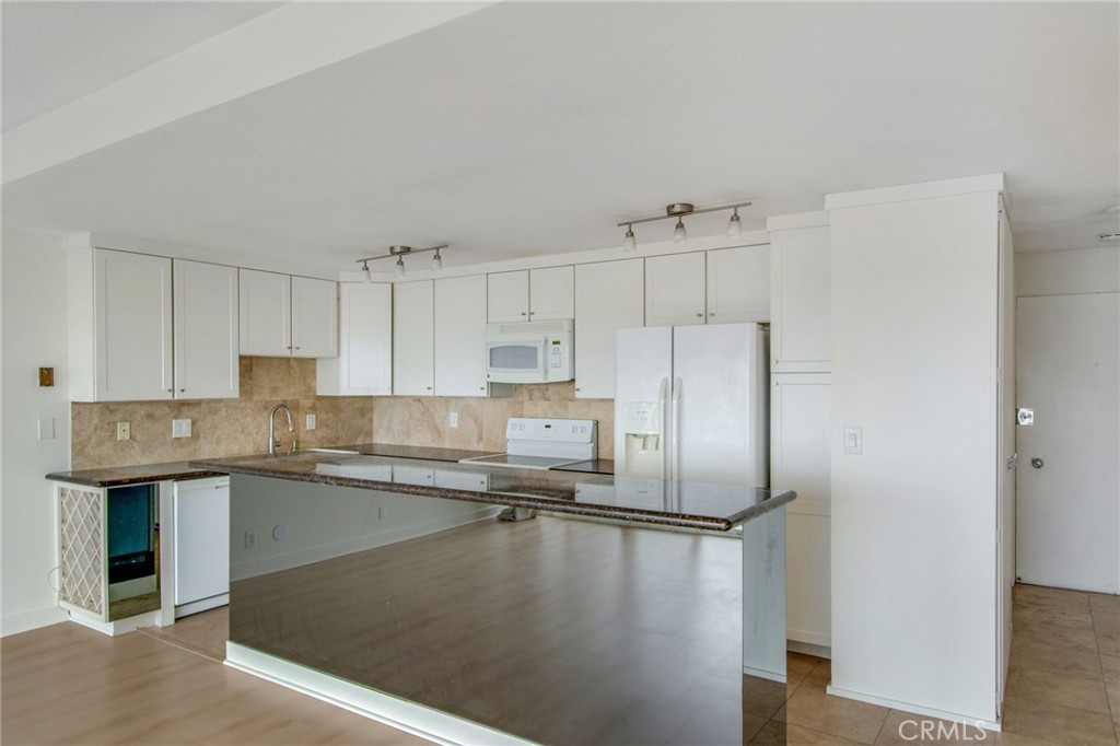 330 Cliff Drive, Unit 308 Laguna Beach, CA 92651 - Photo 8 of 16 a kitchen with stainless steel appliances granite countertop a refrigerator a sink a stove and oven