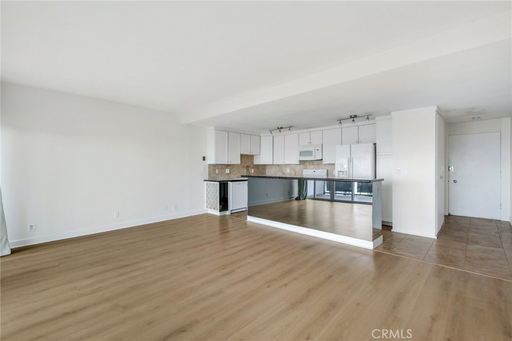 330 Cliff Drive, Unit 308 Laguna Beach, CA 92651 - Photo 9 of 16 a large white kitchen with wooden floor