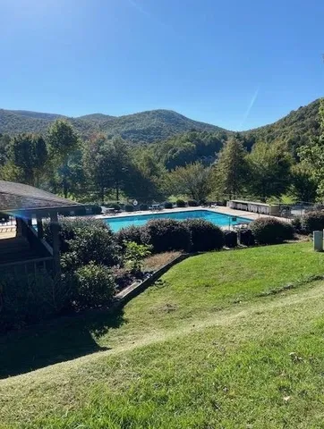 a view of green field with mountains in the background