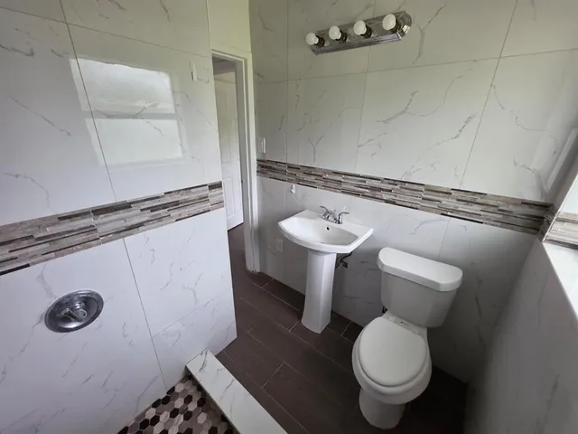 a bathroom with a toilet sink and mirror