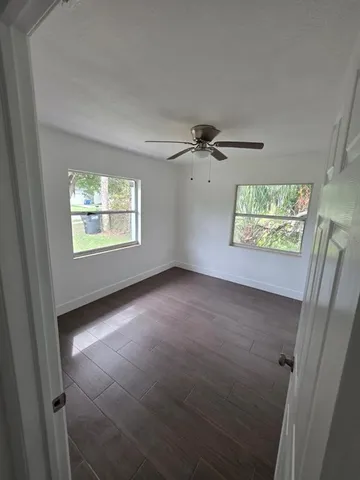 a view of a hallway with wooden floor and closet