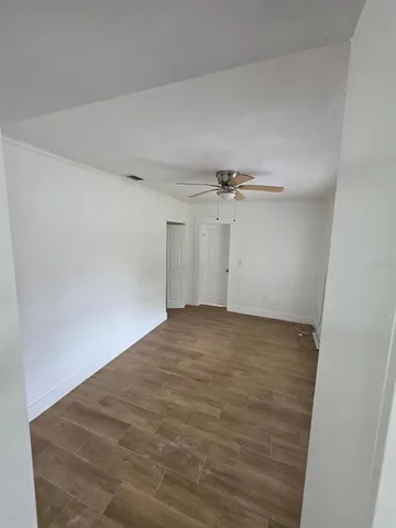 an empty room with closet and a ceiling fan