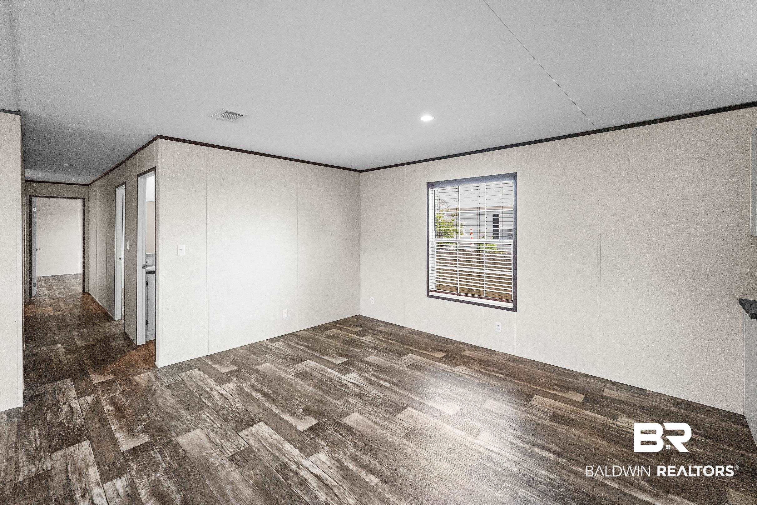 21601 Westside Loop Silverhill, AL 36576 - Photo 28 of 42 Spacious room featuring wood-finish flooring, light-toned walls, and a window with blinds
