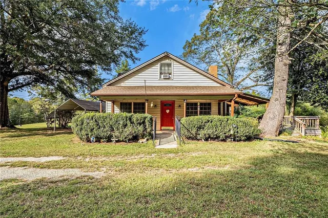 a front view of a house with yard and green space